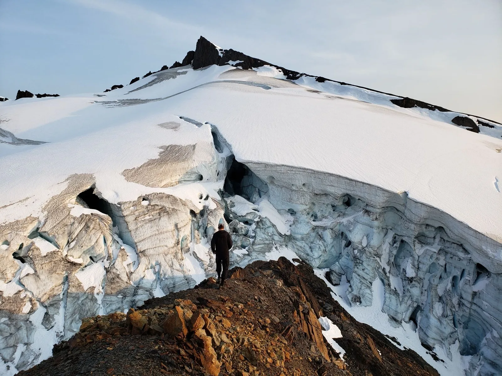 Climber on corniced snow ridge