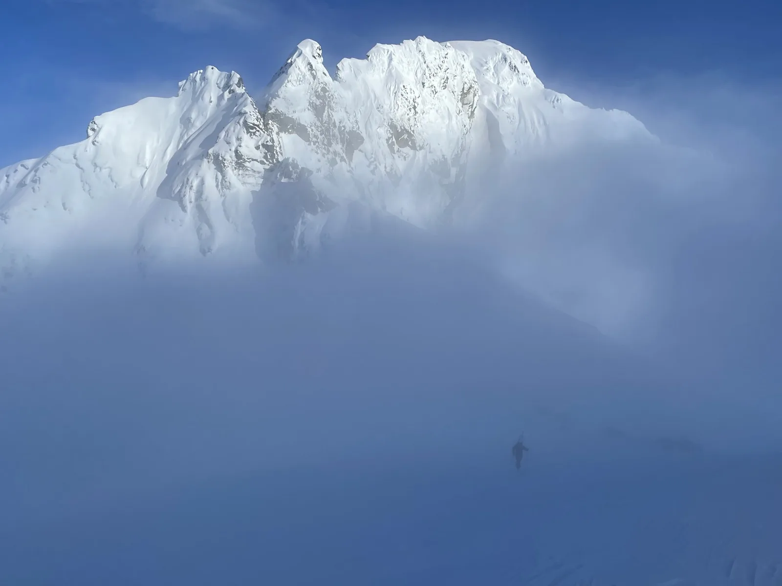 Mountaineer approaching peak in fog